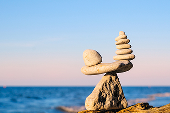 stones in balance blue sky and ocean on the background representing Trusts and Estate Planning 